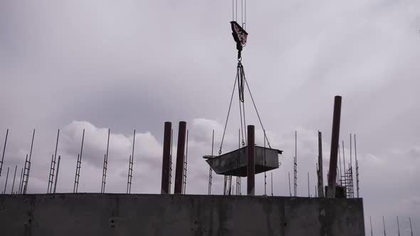 crane moves cargo against the background of cloudy sky