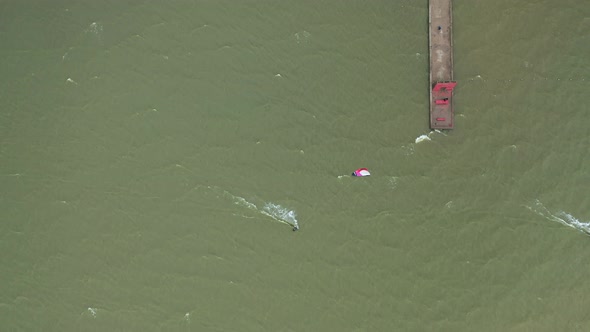 AERIAL: Top View of Surfer Riding Green Wave of Baltic Sea