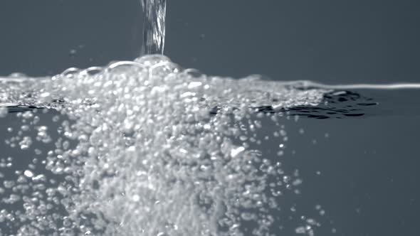 Clean Water Pouring in a Transparent Aquarium with Water. Water Splash, Bubbles, Slow Motion From 60