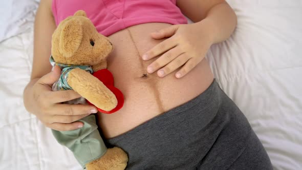 Happy Pregnant Woman Sleeping on Bed in Bedroom