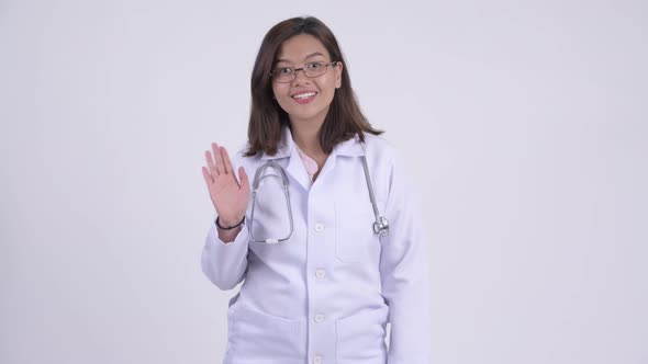 Happy Young Beautiful Asian Woman Doctor Waving Hand