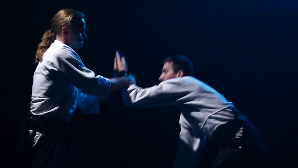 Fight Between Two Aikido Fighters in Dark Studio. Slow Motion. Close Up.