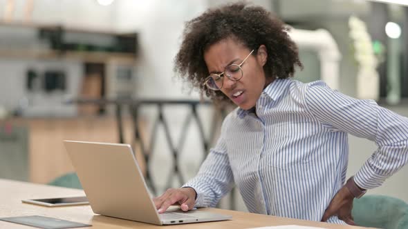 Tired African Businesswoman with Laptop Having Back Pain in Office 