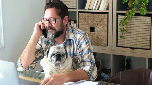 Bearded adult man work at home in office room with his friend dog - people and modern