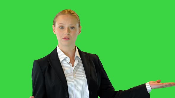 Beautiful Blonde Business Woman Presenting Something Pointing with Her Hand To the Side on a Greenscreen