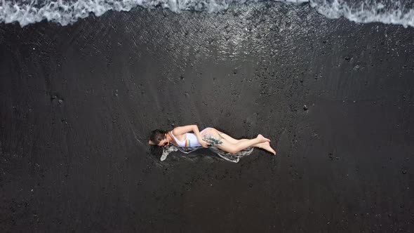 Sexy Lady Lays on Black Sand Beach White Bodysuit