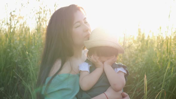 Koreans Family Mother and Daughter in Green Dresses Sitting in the Long Grass