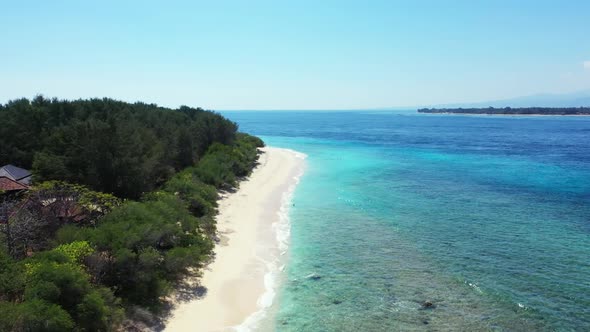 Aerial drone shot tourism of relaxing shore beach trip by blue water with bright sandy background of