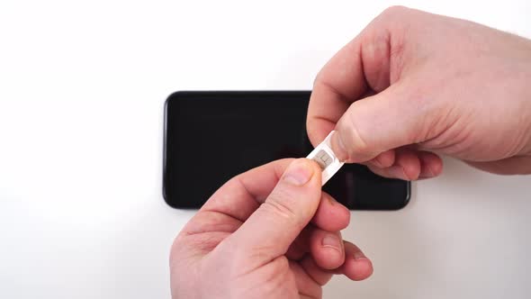 Men's Hands Pull Out a Nano Sim Card From the Adapter Mini Sim Card