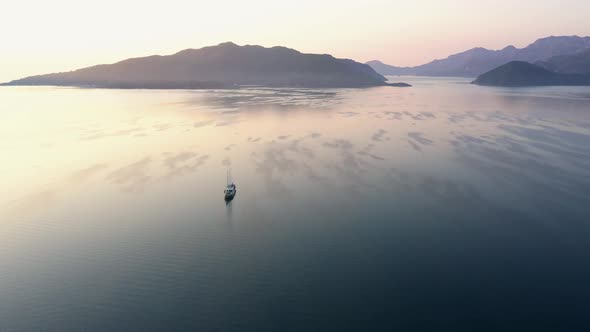 Aerial View of Sea Bay with Lonely Boat and Mountains in the Background