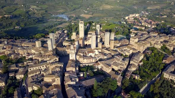 The Italian town of San Gimignano with Torre Grossa and basilica center, Aerial wide circle shot