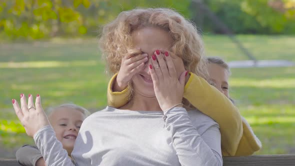 Close-up Portrait of Young Caucasian Curly Blond Woman Sitting on the Bench in the Autumn Park