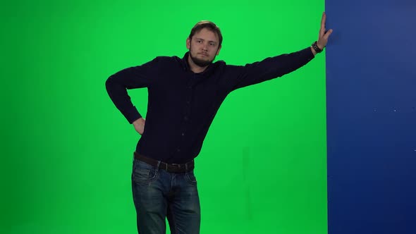 Man Leaning Hand on Wall Standing Against Chroma Key Background
