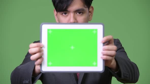 Young Handsome Asian Businessman Using Digital Tablet