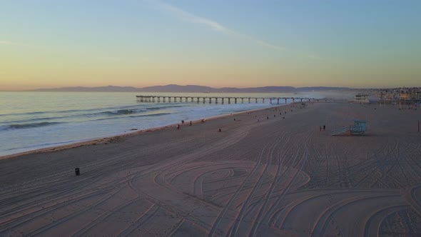 Aerial drone uav view of a pier at sunset at the beach and ocean.