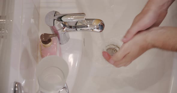 Corona Virus Prevention Man Showing Hand Hygiene Washing Hands with Soap in Hot Water. Using Soap