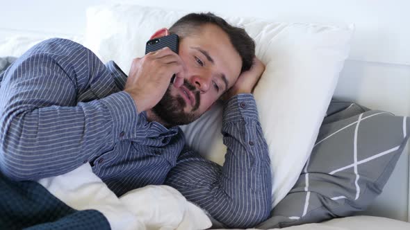 Man Talking on Phone while Lying on Side in Bed
