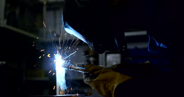 Employee in Welding Mask Connects Details with Modern Tool
