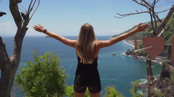 Girl Standing on a Cliff and Looking at the Sea. Bali, Indonesia