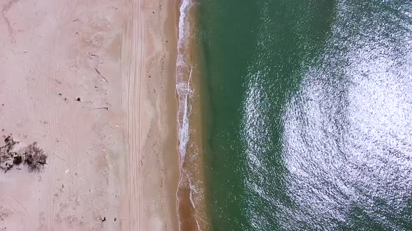 Vertical orientation video: Small sea waves. Soft waves on a sandy beach. Seascape background