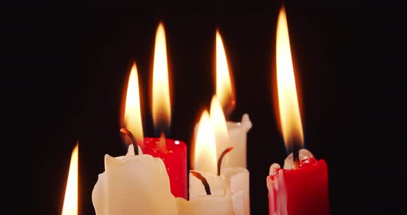 Burning White and Red Candles on a Black Background