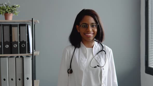 Portrait of Handsome Indian Female Doctor Wearing White Coat and Stethoscope Crosses Arms Standing