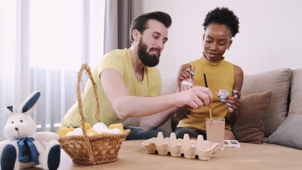 Black Woman and European Man Painting Easter Eggs Together