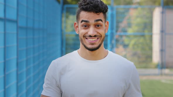 Attractive Middle Eastern Indian Young Male Athlete Standing in Stadium in Sportswear Waving Hand