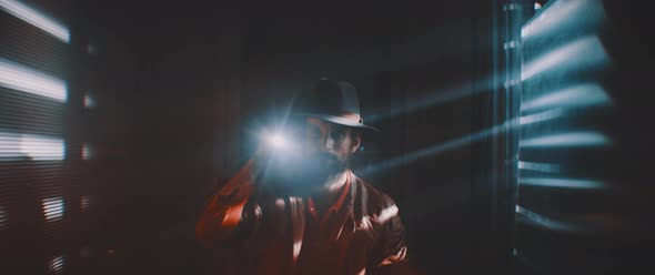 Man flashing flashlight towards camera in lights of shutters