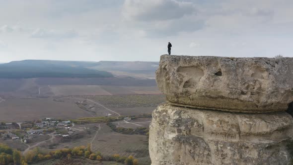 Aerial Panoramic View Active Hiker Couple Hugging on Top of White Rock Surrounded By Hilly Terrain