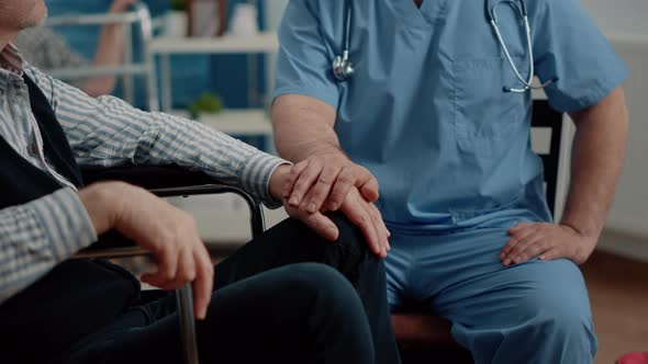 Close Up of Hands of Man Nurse Comforting Senior Patient