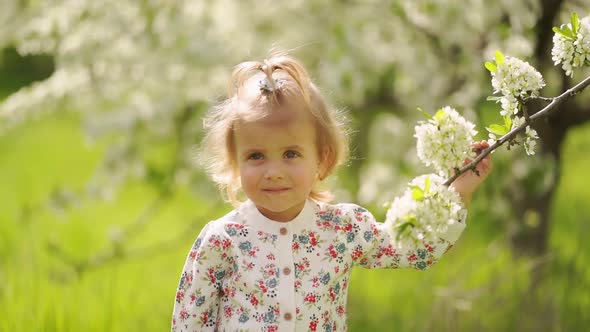 Little Girl at Flowering Tree in Garden