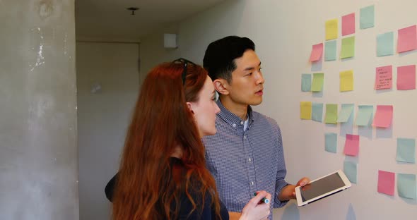 Business executives discussing over sticky notes