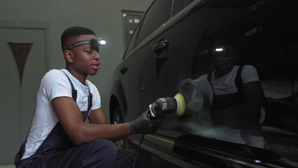 A Young AfricanAmerican Polishes a Car