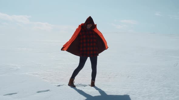 Girl Dancing on a Sunny Snowy Field in Winter