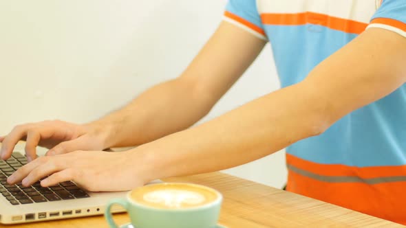 Man using laptop while drinking coffee