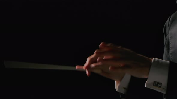 Symphony Orchestra Conductor Wearing Suit is Directing Musicians with Movement of Baton Isolated on