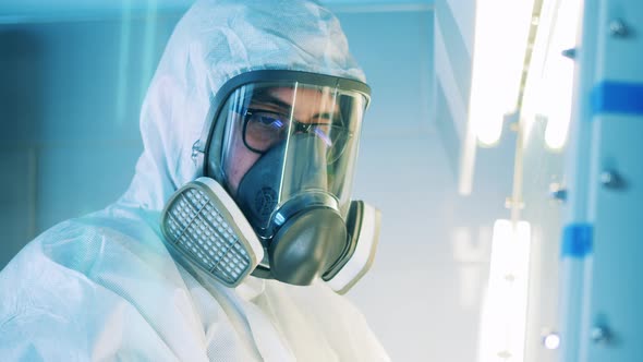 Male Specialist in a Hazmat Suit is Working in a Laboratory