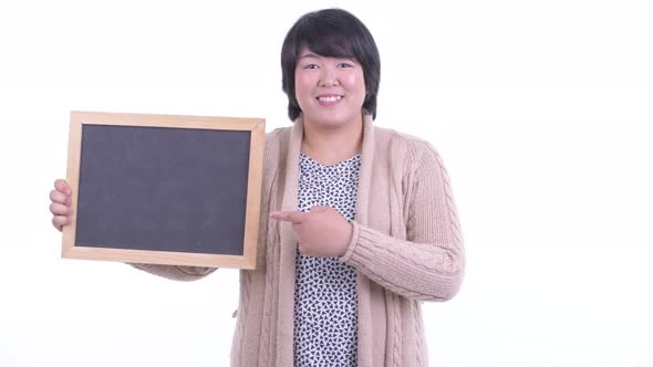 Happy Overweight Asian Woman Holding Blackboard and Giving Thumbs Up for Winter