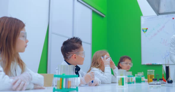 Group of Kids Making Experiments in Chemistry Class