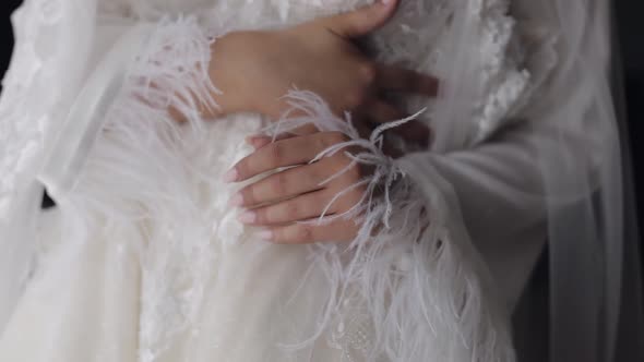 Bride in Lingerie Standing with Her Wedding Dress at Home Near Window White Boudoir Dress and Veil