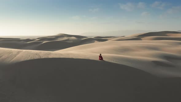  Aerial of the Woman in a Red Dress in the Middle of Sand Dunes and Desert