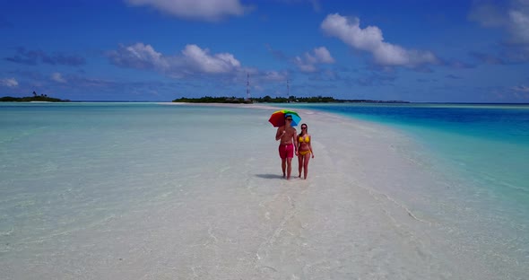 Beautiful man and woman on romantic honeymoon spend quality time on beach on paradise white sand