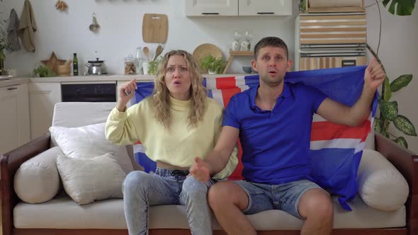 A Family of Fans of the Icelandic National Team Watch TV at Home with the Icelandic Flag