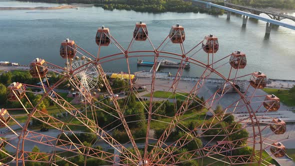 Drone View Colorful Ferris Wheel in Amusement Park on River and City Landscape