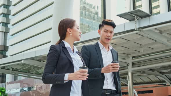 Asian young office business people stand outdoor in city with confident face holding hot coffee.