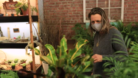 Woman Wearing Mask Looking at Plants in Shop