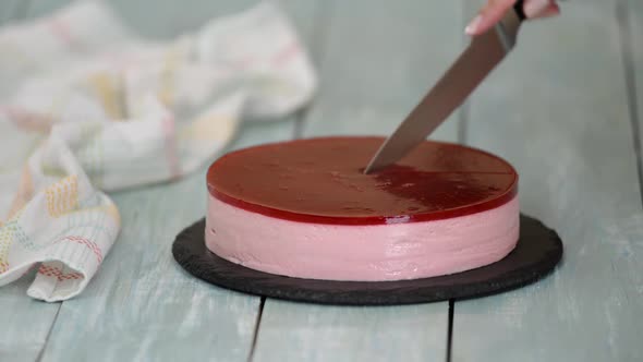 Close-up of Woman Cutting Fruit Mousse Cake.