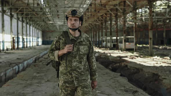 Man in Helmet and Military Uniform Walking on Old Factory