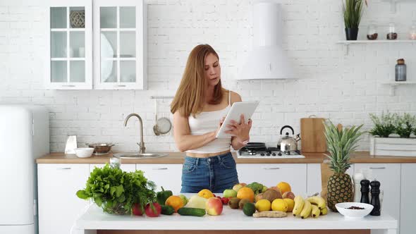 A girl with a tablet in her hands is looking for recipes